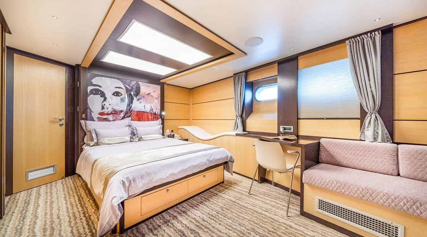 Navilux motor yacht master cabin with large bed, wood accents, and porthole windows