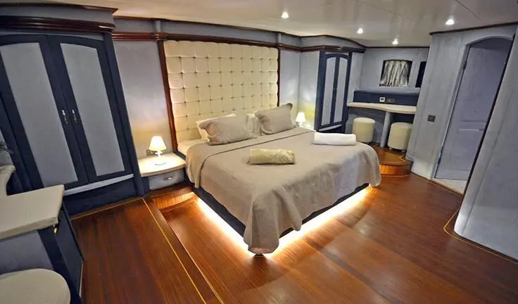 Bella Mare master cabin with large bed, wood floor, and soft lighting