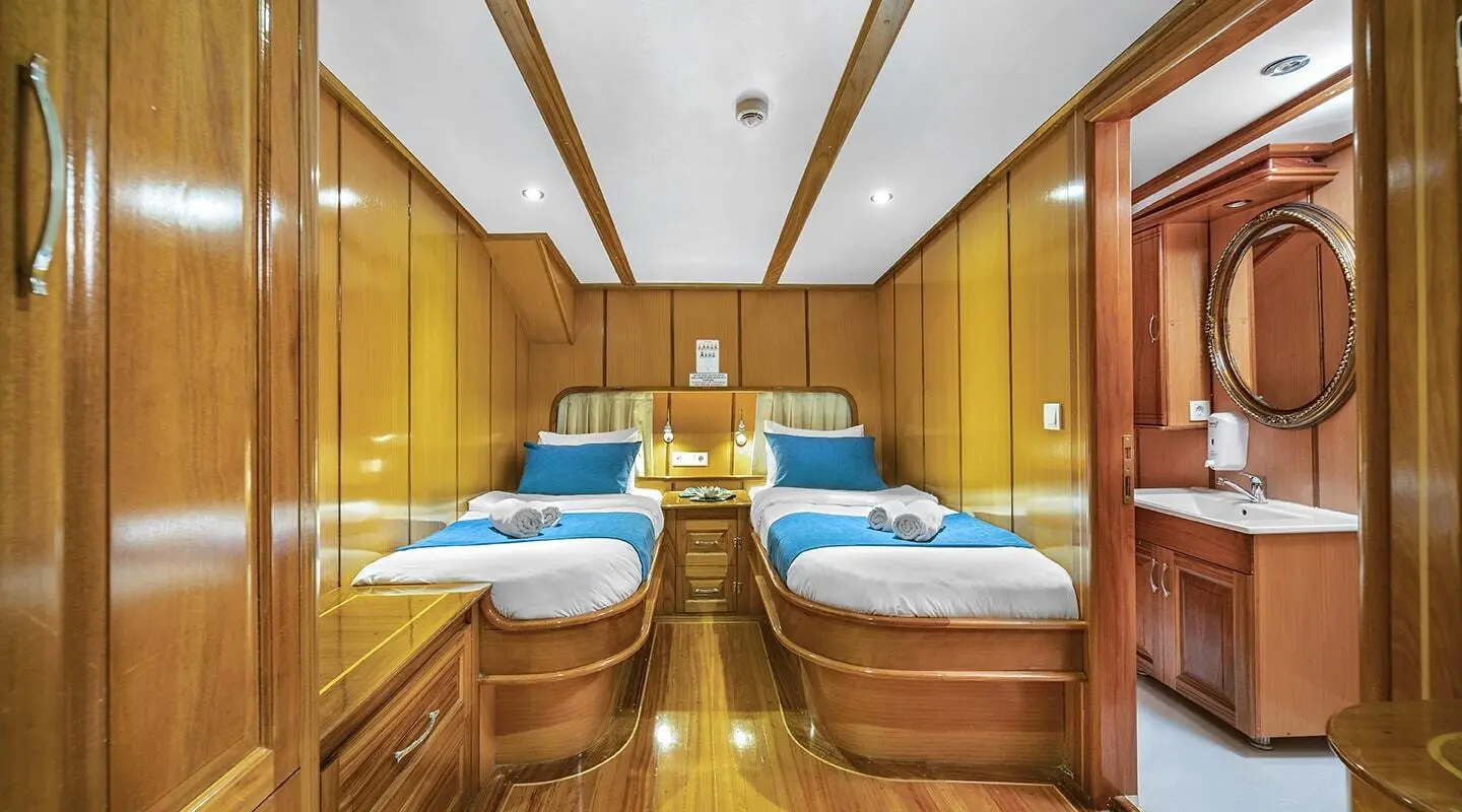 Luxurious yacht cabin interior with polished wood panels and blue bedding