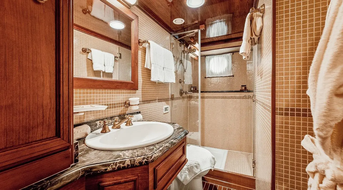 Seagull II yacht bathroom interior with sink, wood cabinets, and shower