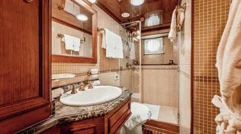 Seagull II yacht bathroom interior with sink, wood cabinets, and shower