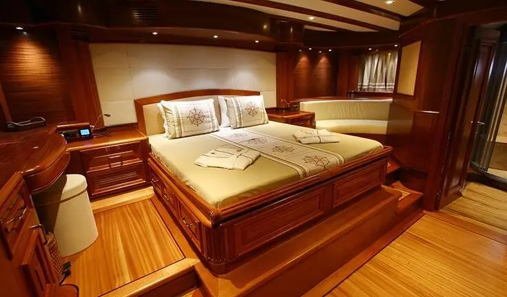 Master cabin with king bed, wood tones, ensuite bathroom visible, Kaya Guneri 5