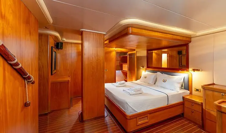 Twin bed cabin with white bedding and wooden panel walls aboard Mein Schatz