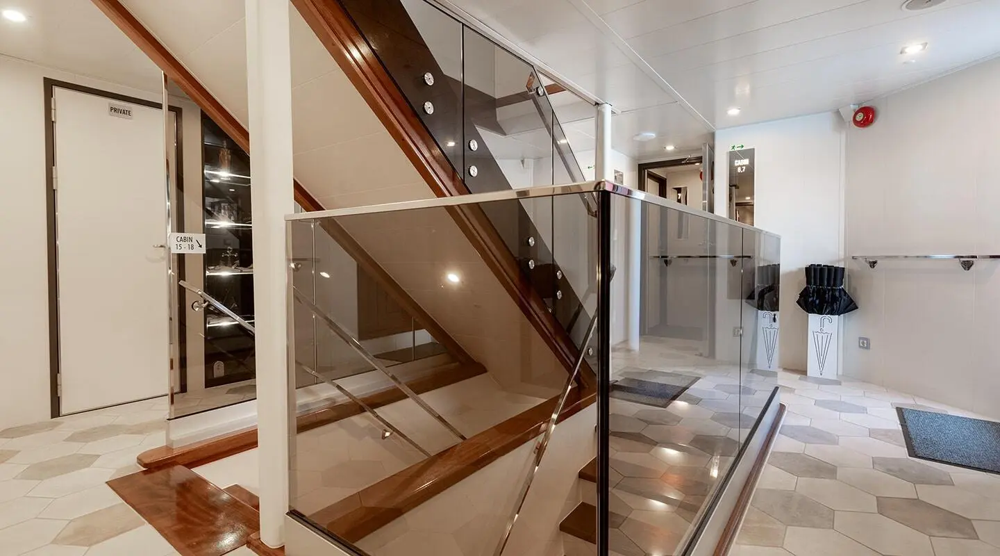 Yolo yacht interior hallway with glass railing and staircase, modern white walls
