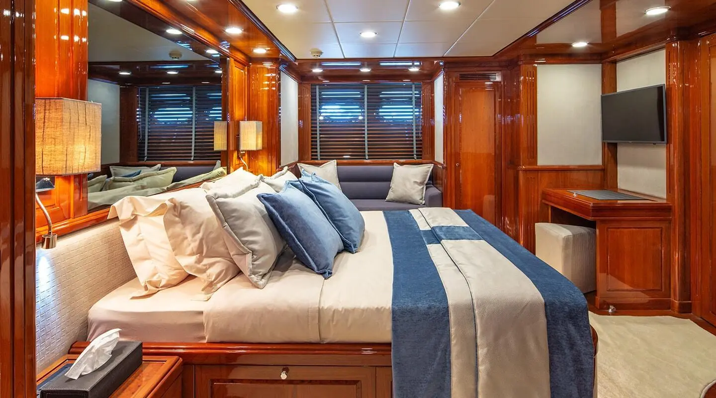 Divine luxury yacht bedroom with polished wood, bed, and blue-grey bedding
