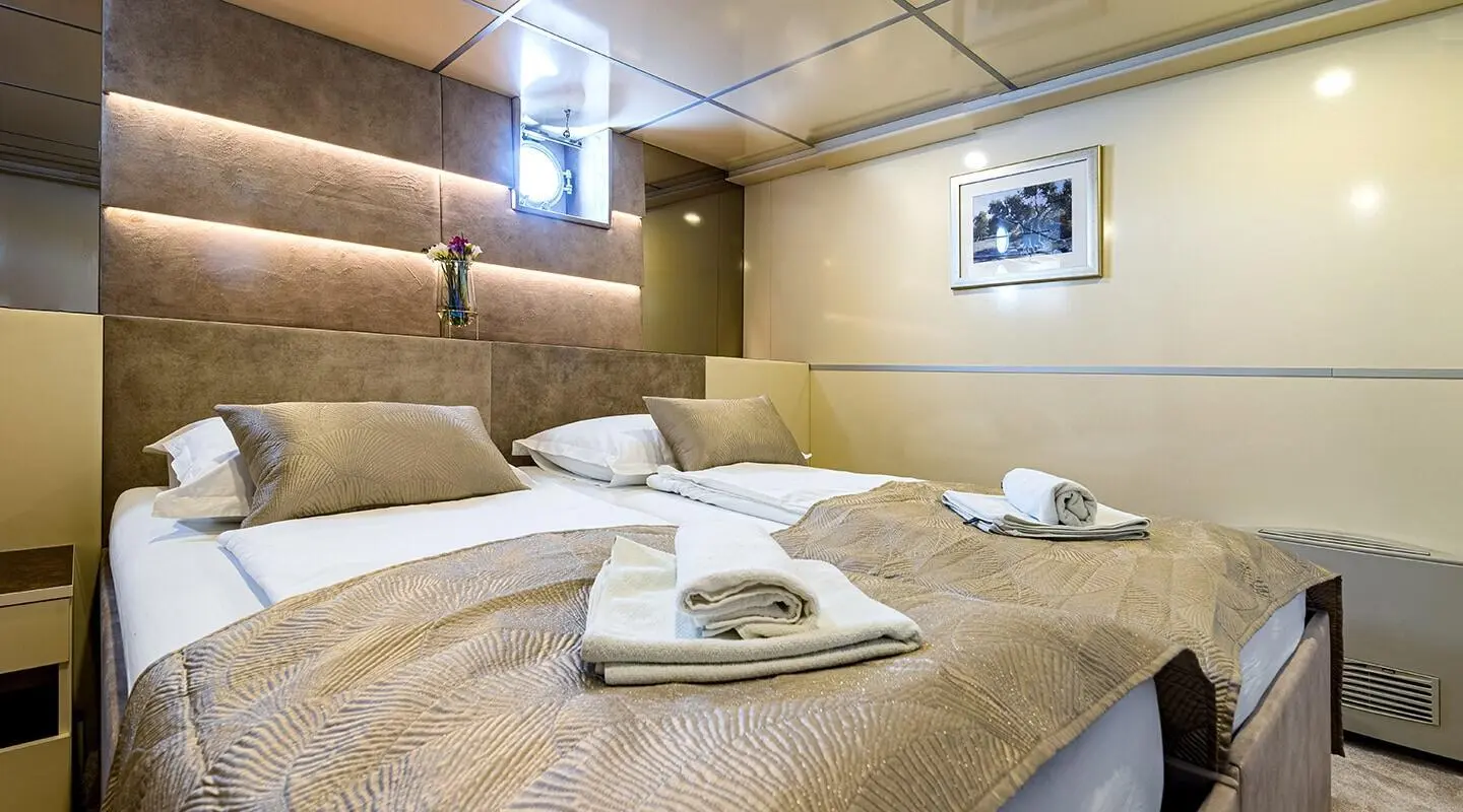 Yacht Melody lounge deck with beige upholstery, cushions, and round coffee table