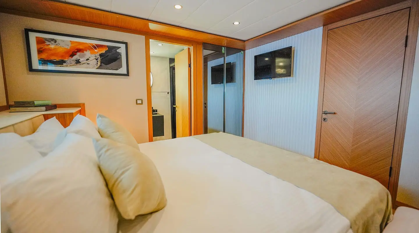 King Of The Sea luxury yacht cabin with a large bed and warm wood accents