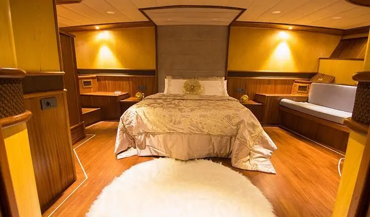 Nevra Queen master cabin with king bed, ensuite, warm wood tones and lighting