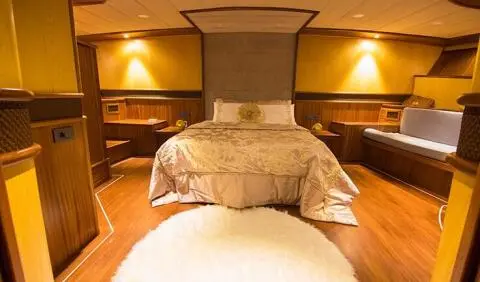 Nevra Queen master cabin with king bed, ensuite, warm wood tones and lighting