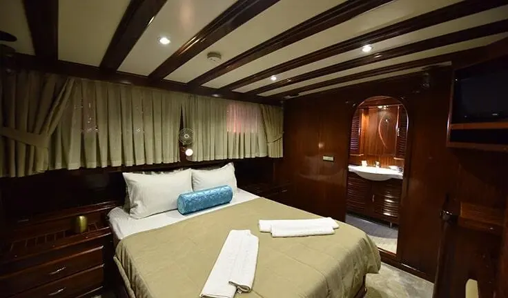 Cozy cabin aboard Kayhan Kaptan showing two single beds with pillows