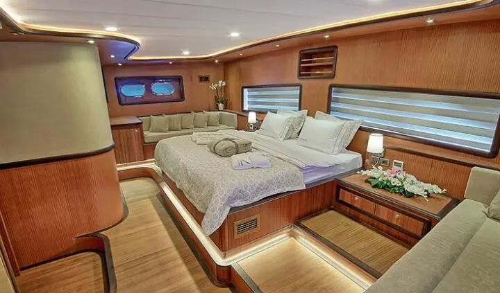 Queen of Salmakis cabin interior with bed, wooden panels, and amenities
