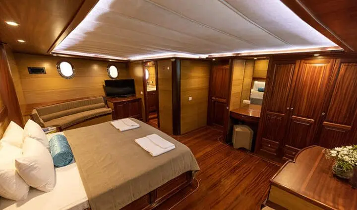 Interior of Kayhan 4 cabin with bed, wood floor, and cabinetry visible