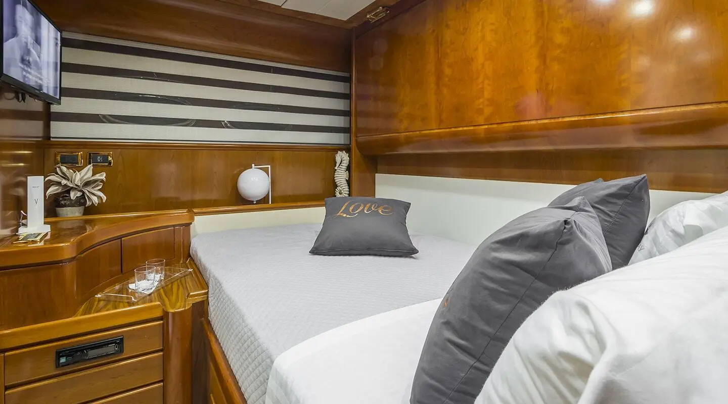 Interior of Amoraki luxury yacht bedroom with wood paneling and bed