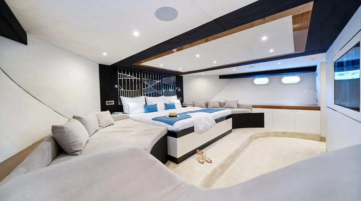 Interior of Acapella yacht saloon with white seating and dark wood accents