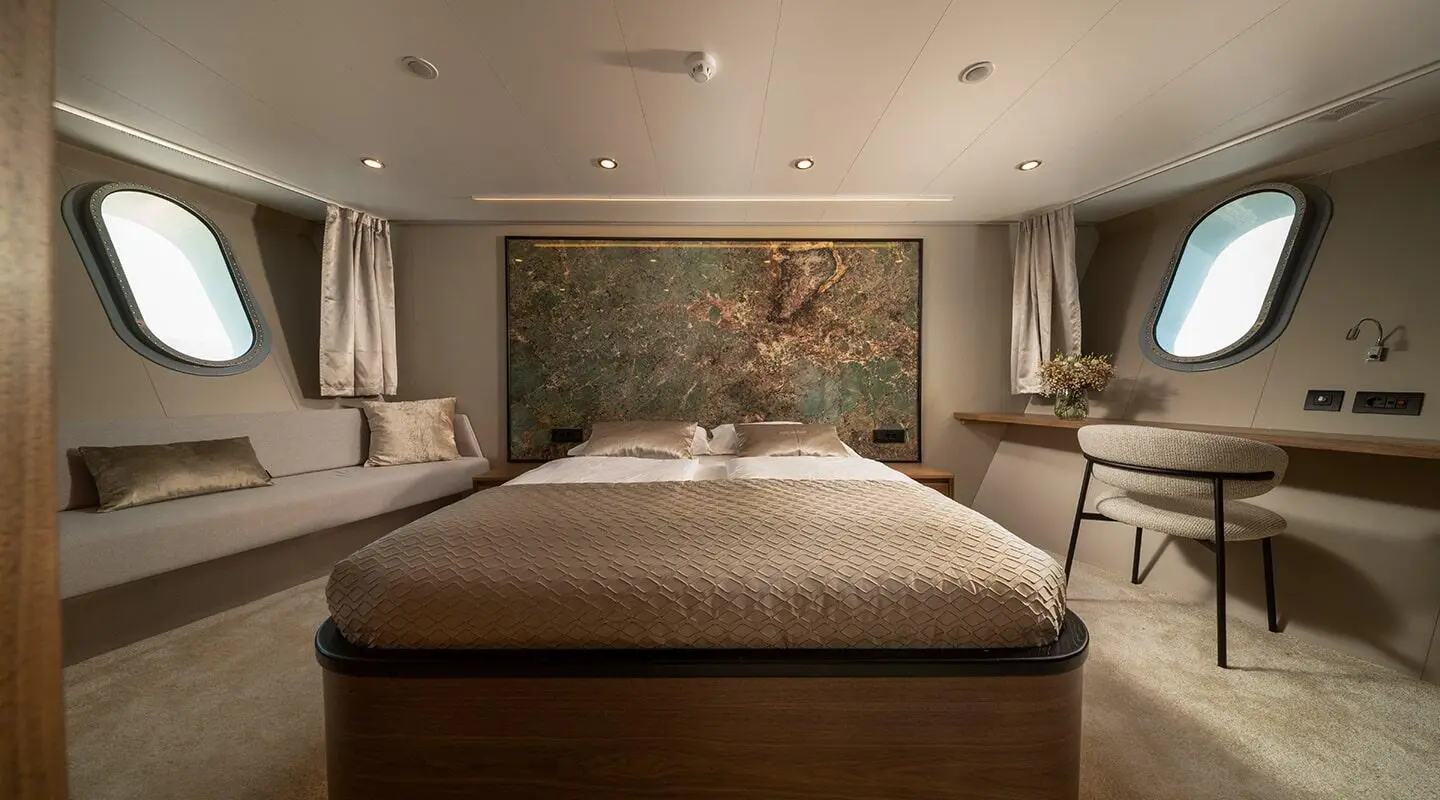Olimp luxury yacht bed cabin with beige bedding and warm lighting