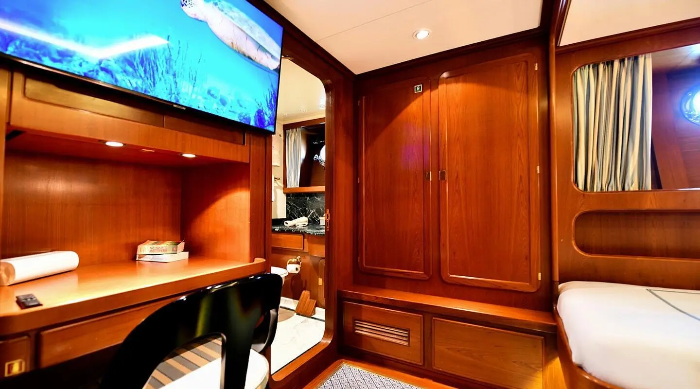 Tamarita yacht interior with polished wooden cabinetry and warm lighting