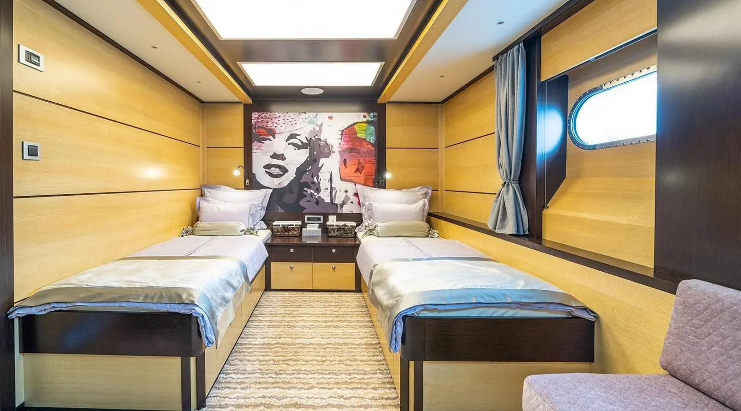 Navilux yacht deck area with two side-by-side beds and wooden flooring