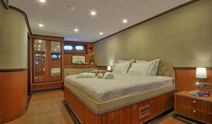 Queen of Salmakis master cabin with king bed, wood cabinetry and ensuite