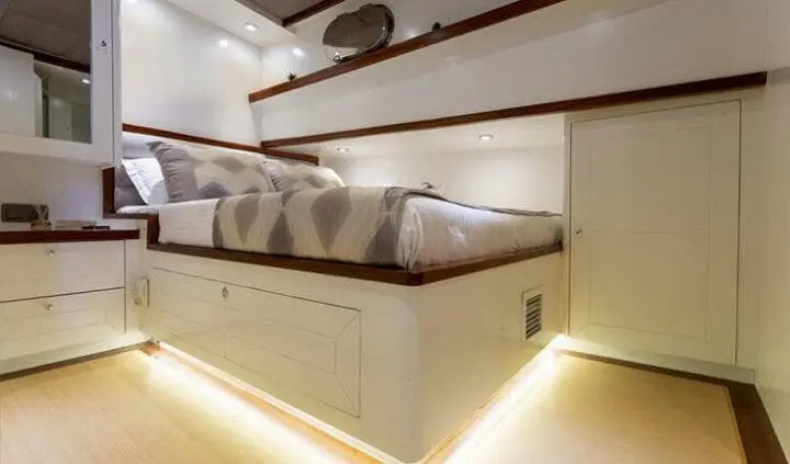 Grand Sailor yacht cabin with a large bed, beige upholstery, and wooden detailing