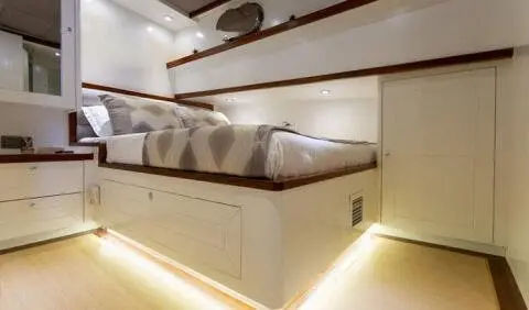 Grand Sailor yacht cabin with a large bed, beige upholstery, and wooden detailing