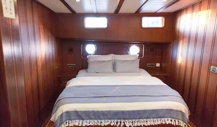Primadonna yacht cabin with king bed and en-suite visible in wood-paneled interior