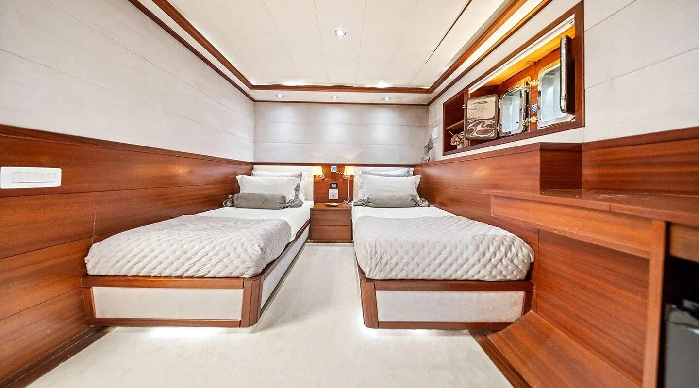 Interior of Alessandro I gulet with twin lounge beds and wooden cabinetry