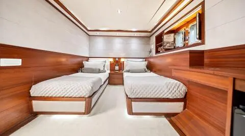 Interior of Alessandro I gulet with twin lounge beds and wooden cabinetry