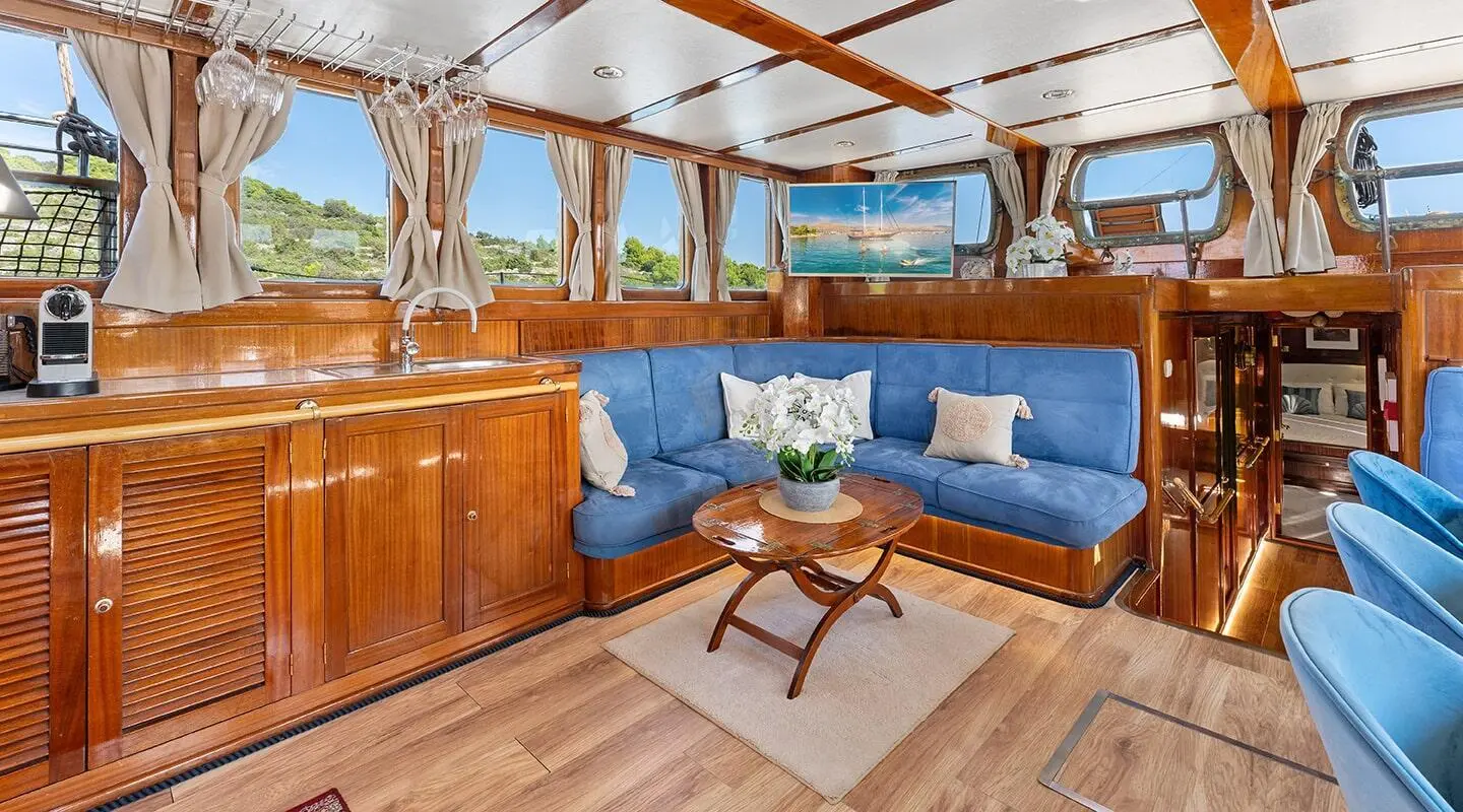 Wood-paneled interior with blue upholstered seating and central coffee table