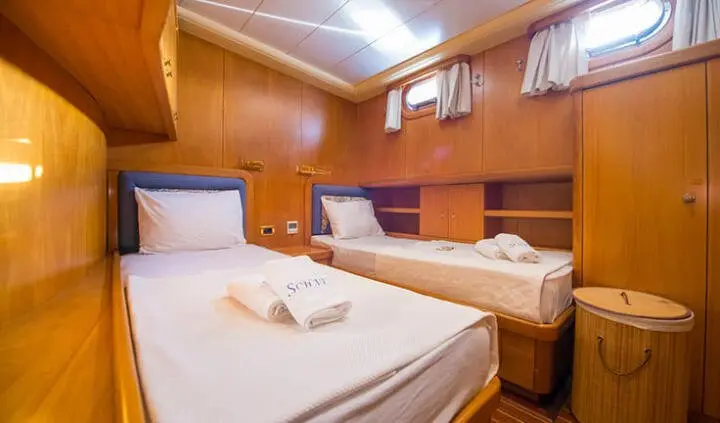 Two single berths with white bedding and wooden cabin panels on Mein Schatz