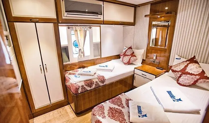 Maske 2 master cabin with king bed, ensuite, wood paneling, window, and seating