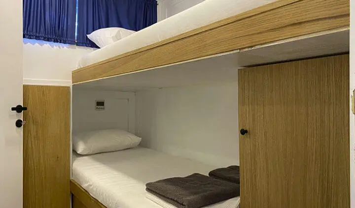Maske 5 yacht cabin bunk area with single bed and folded towels