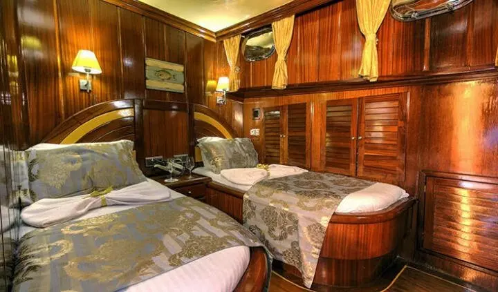Diva Deniz yacht cabin with neatly made twin beds and wooden cabinetry