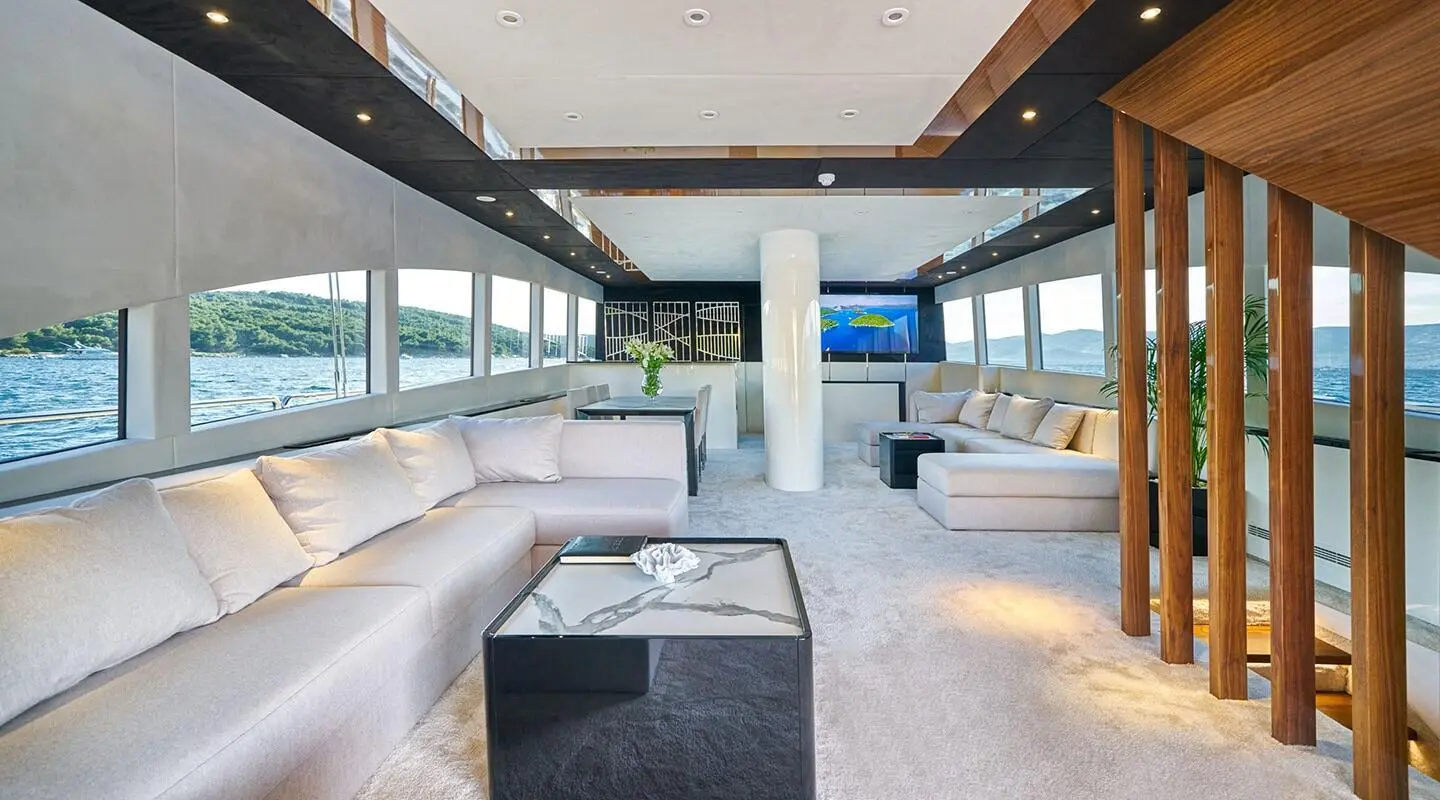 Spacious lounge with light-colored sofas and a central coffee table in a yacht interior