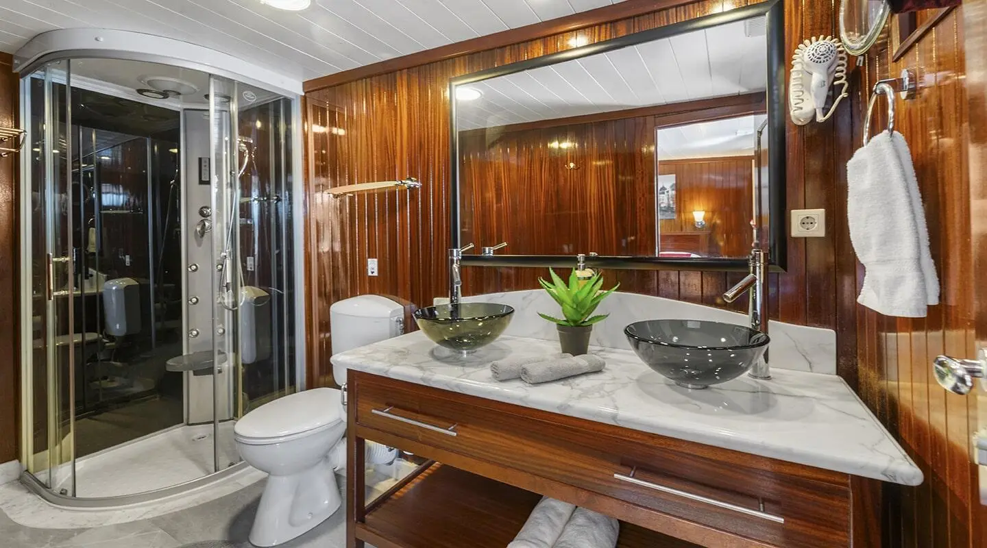 Cesarica luxury gulet interior with wooden cabinetry, dining table, and seating.