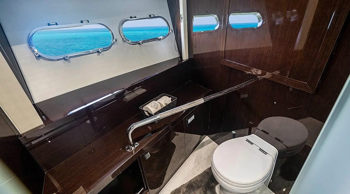 Inside a luxury Quantum yacht salon with dark wood, white seating, and windows