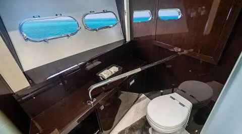 Inside a luxury Quantum yacht salon with dark wood, white seating, and windows