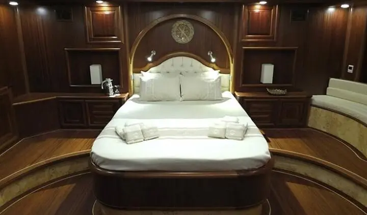 Luxurious cabin aboard Kaptan Mehmet Bugra gulet with twin bed and dark wood decor