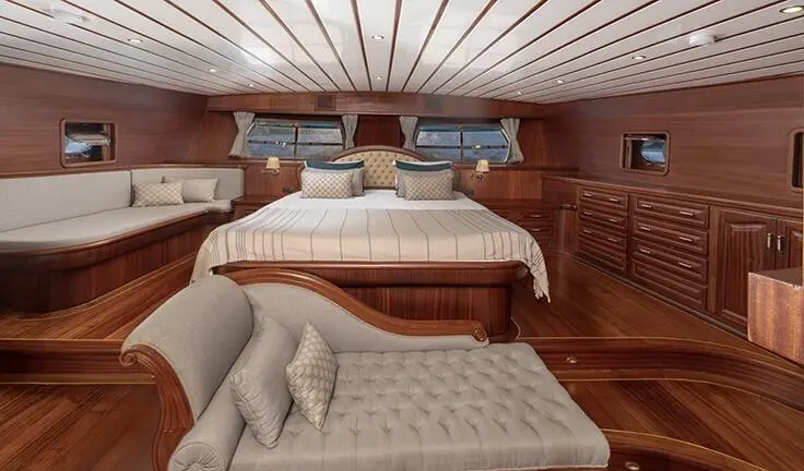Gulet Bedia Sultan master cabin with wooden interior, bed and seating area