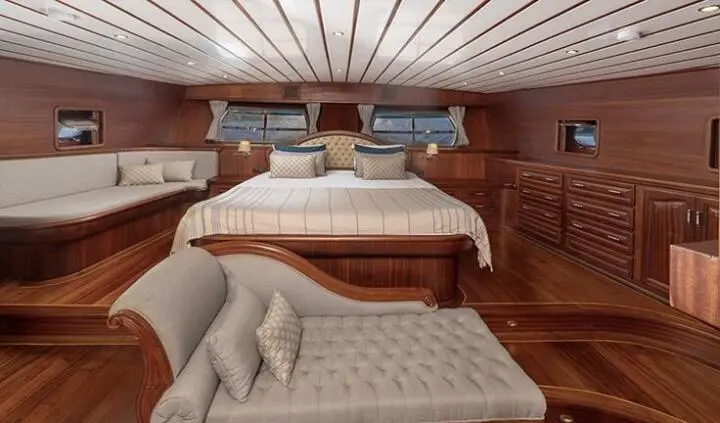 Gulet Bedia Sultan master cabin with wooden interior, bed and seating area