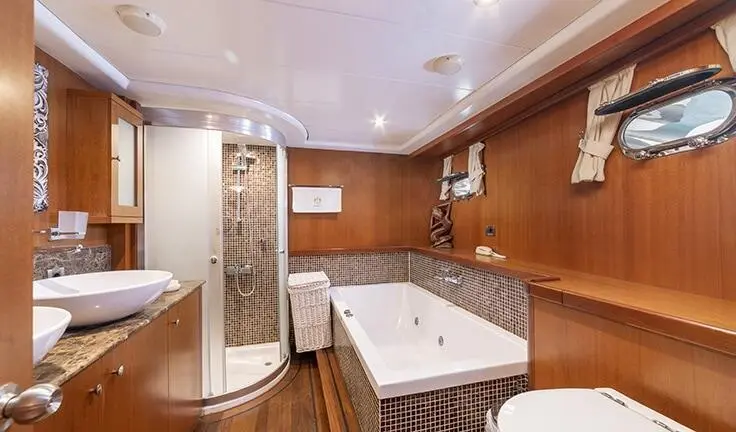Yacht Arabella cabin bath area with marble counters and wood paneling