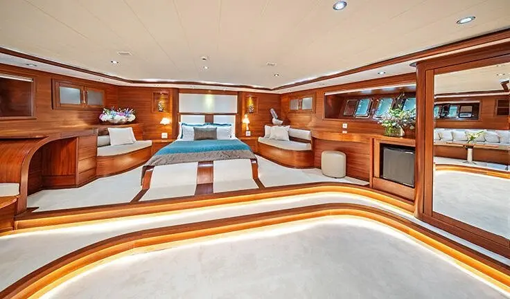 Interior of gulet Alessandro I master cabin lounge with wooden cabinetry and seating.
