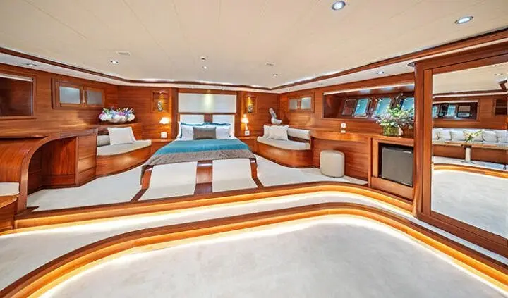 Interior of gulet Alessandro I master cabin lounge with wooden cabinetry and seating.