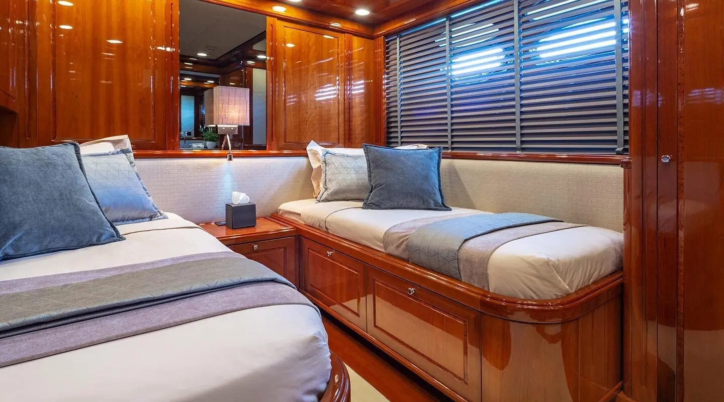 Interior of Divine luxury yacht cabin with two single beds and wood accents
