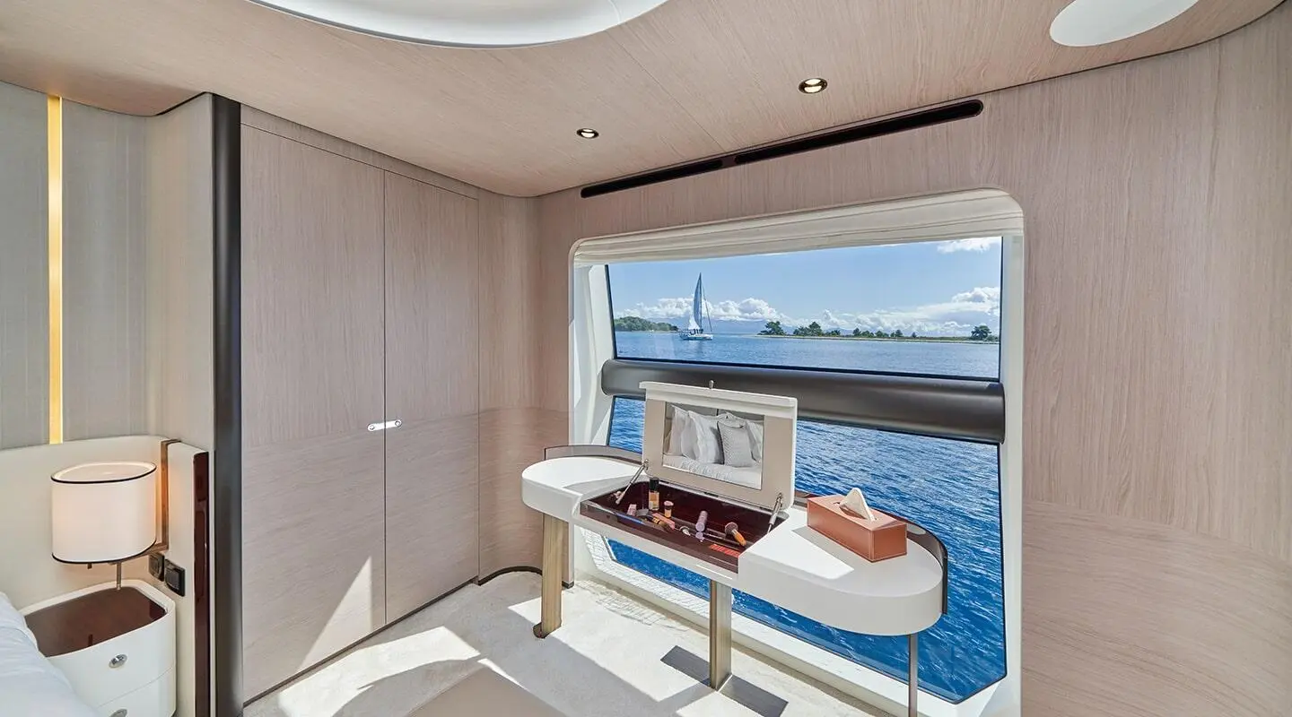 Luxurious yacht interior with seating, TV, and ocean view through window