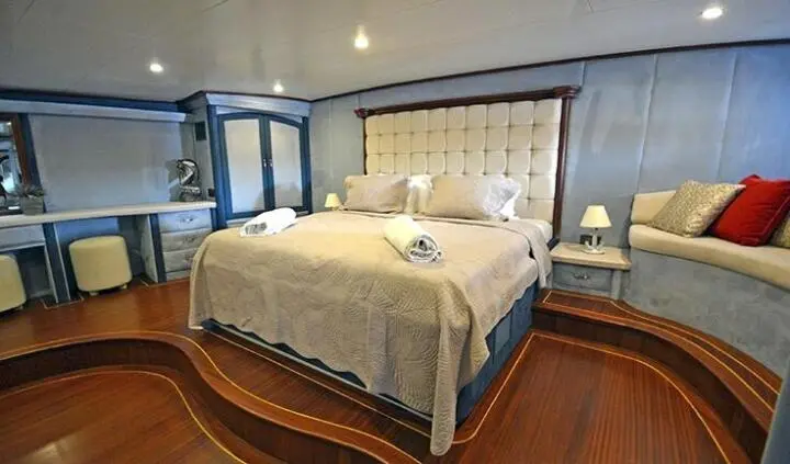 Bedroom aboard Bella Mare: queen bed with tufted headboard and bedside tables