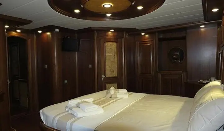 Master cabin with king bed, ensuite layout and wood paneling