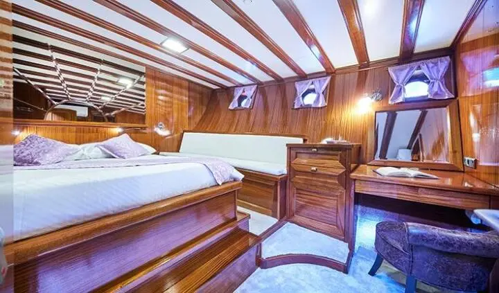 Stella Maris master cabin interior with wood paneling and beds