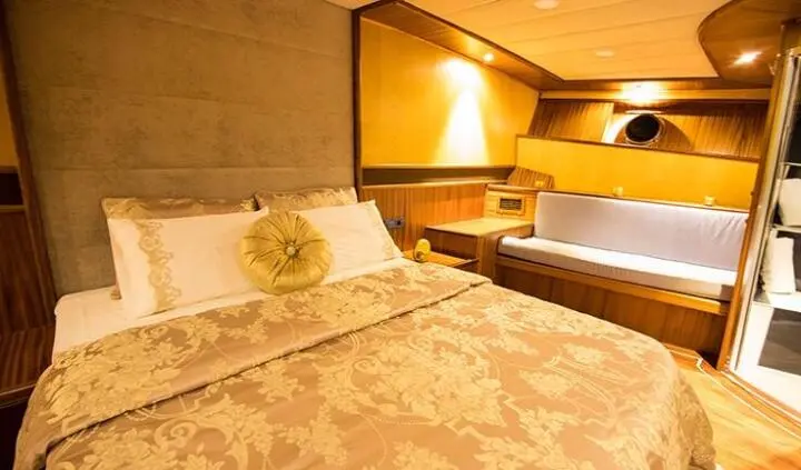 Nevra Queen master cabin with king bed, plush bedding and warm lighting