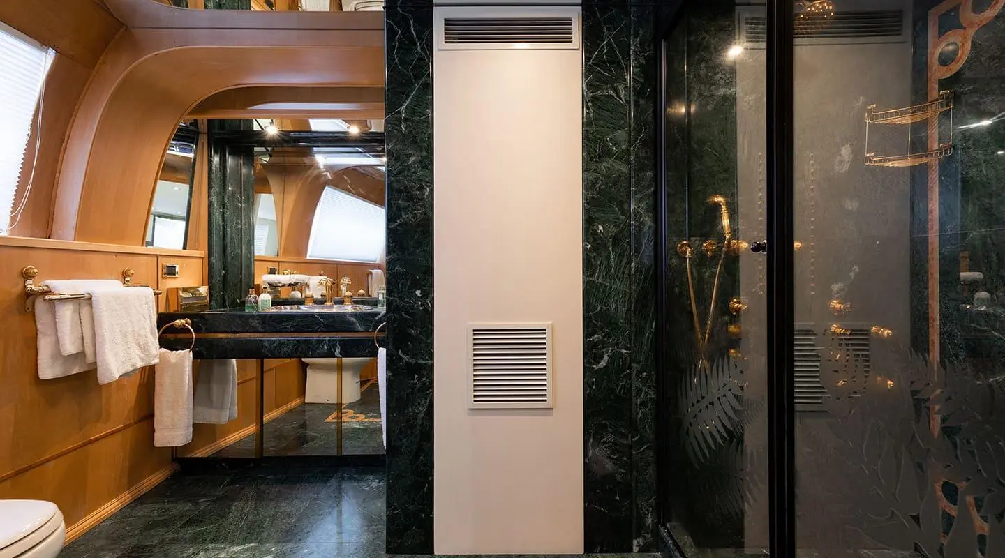 Interior of a luxury yacht bathroom with a dark glossy door, light-colored walls, and a vent
