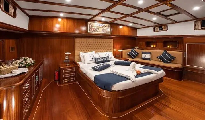 Interior view of Estrella De Mar master cabin with wooden panels and large bed